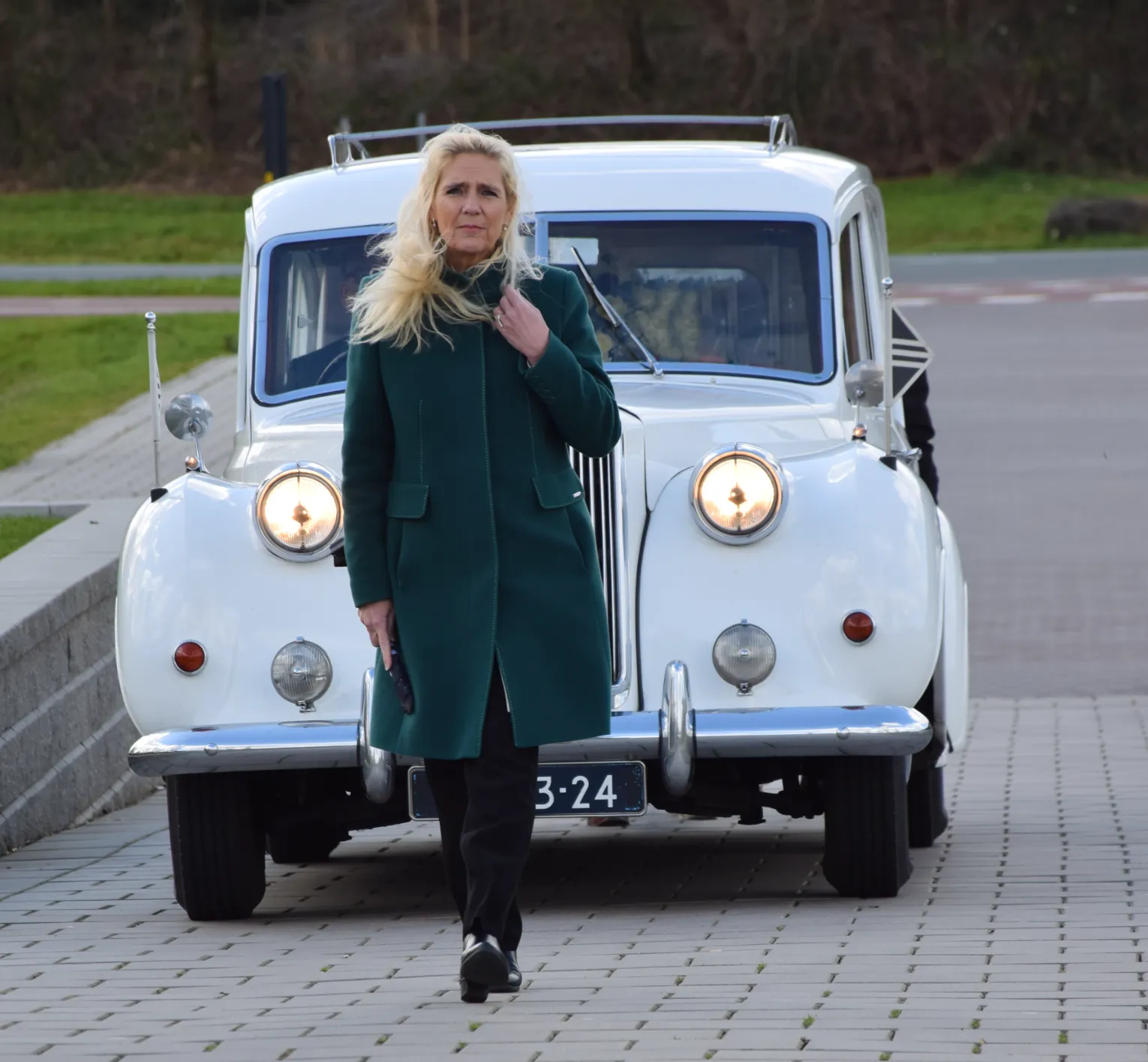 monique kupras loopt voor een oldtimer rouwauto crematorium-meerbloemhof